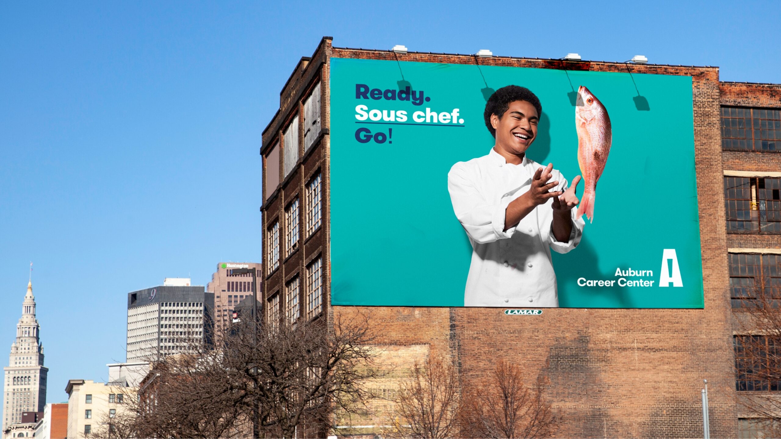 billboard of person throwing a fish on a brick building