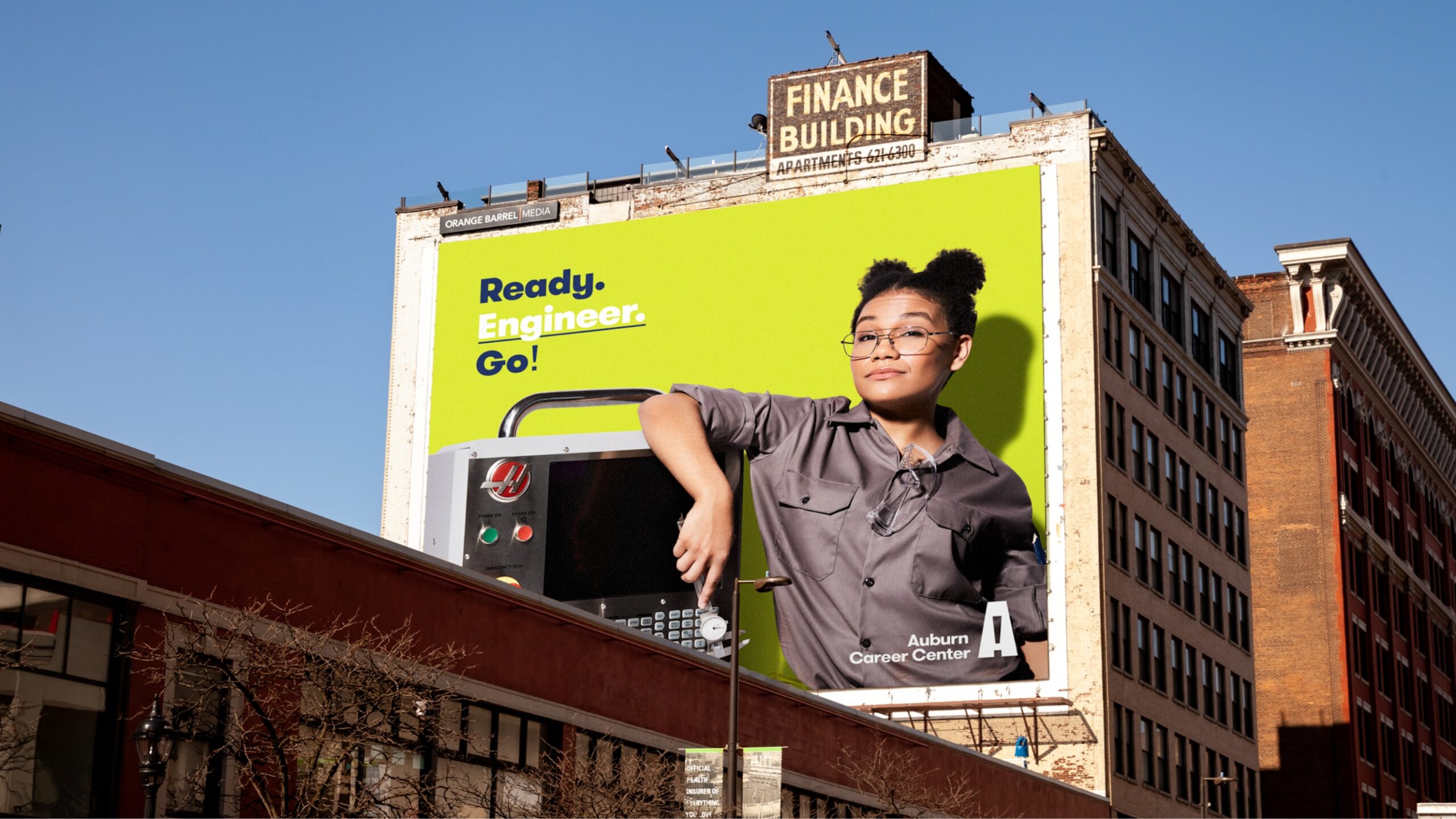 billboard of woman standing next to an automotive machine on a brick building