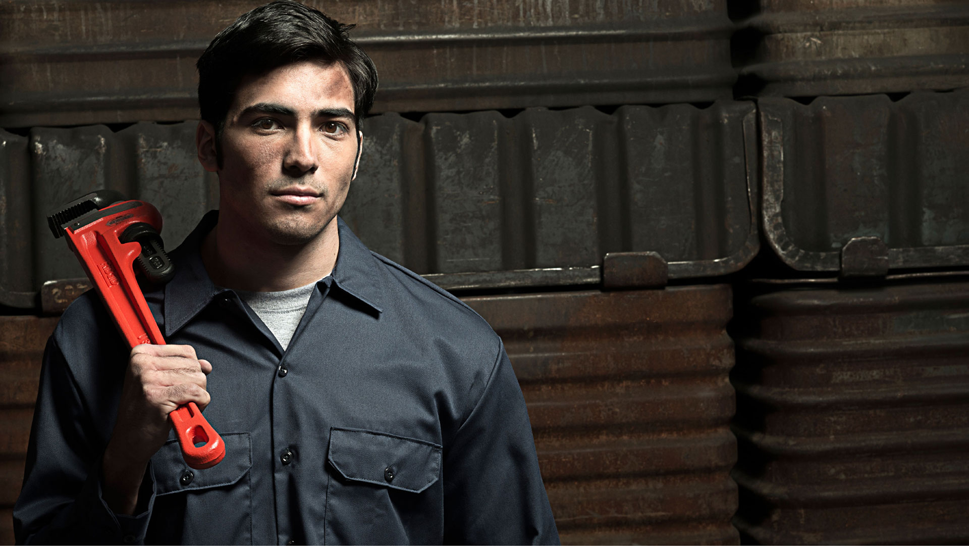 blue collar working holding a wrench