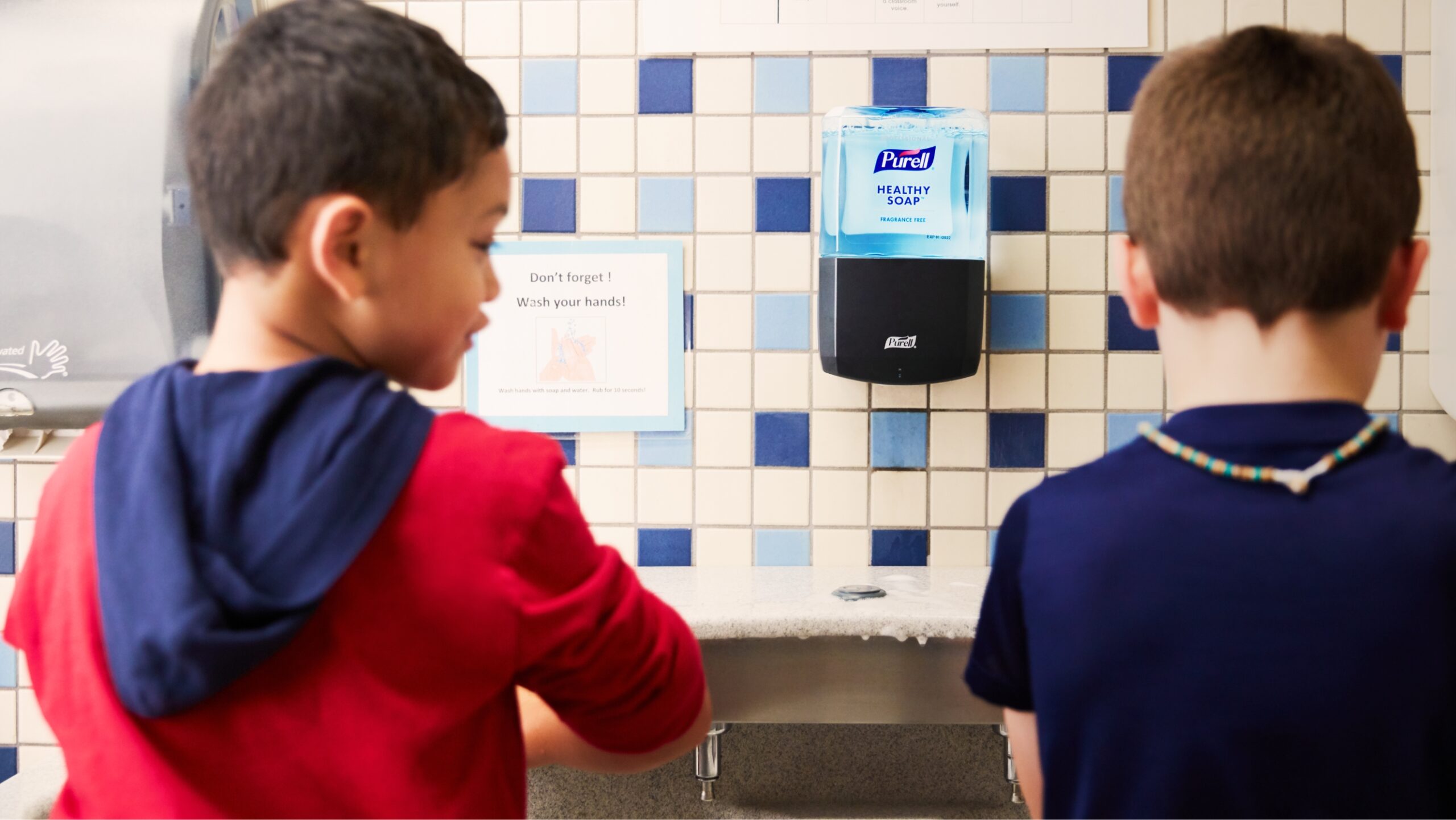 Two male students washing hands in sink