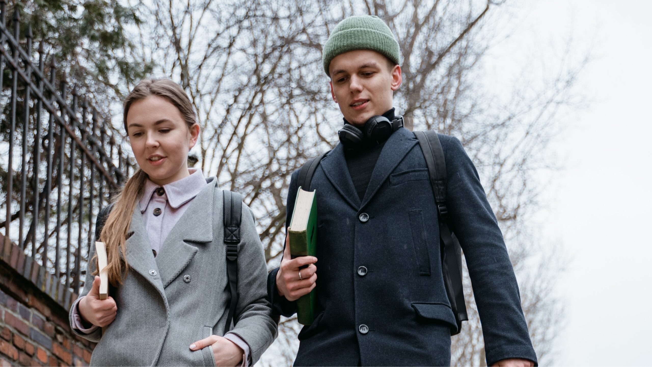 Two students walking outside with books